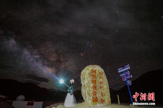 圖為6月20日晚，游客“打卡”西藏阿里暗夜公園，天上是銀河與流星（右上角）。曹枝清 攝