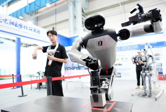 9月5日，在沈陽(yáng)的2025全球工業(yè)互聯(lián)網(wǎng)大會(huì)的展覽區(qū)現(xiàn)場(chǎng)，中國(guó)科學(xué)院沈陽(yáng)自動(dòng)化研究所的機(jī)器人工程師在調(diào)試具身智能操作系統(tǒng)。新華社記者 李鋼 攝